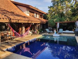 um resort com uma piscina e uma casa em Belíssima Mansão na Assunção em Porto Alegre