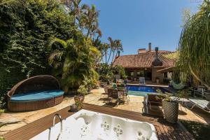 a bath tub in a yard with a swimming pool at Belíssima Mansão na Assunção in Porto Alegre