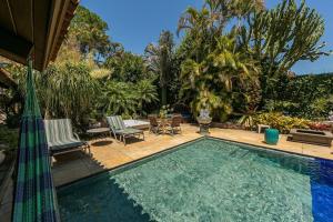 - une piscine avec 2 chaises et une table dans l'établissement Belíssima Mansão na Assunção, à Porto Alegre