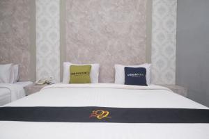 een bed met twee kussens erop bij Urbanview Hotel DJ Inn Tegal in Tegal