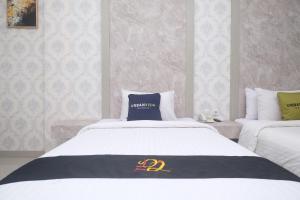 um quarto de hotel com uma cama com um cobertor preto e dourado em Urbanview Hotel DJ Inn Tegal em Tegal
