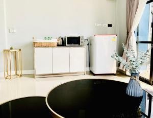 a kitchen with a white refrigerator and a table at Napa in Ban Rai Khlong Sai