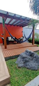 een hangmat op een houten terras met een rots bij Sobrado com 3 Suítes, Piscina, Sala de Jogos, Playground, Garagem para 4 Carros in Florianópolis