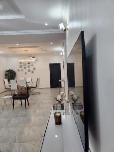 Dvyne Luxury Home في إيكيجا: غرفة معيشة مع طاولة وكراسي