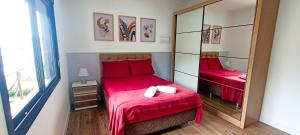 een slaapkamer met 2 bedden met rode lakens en een spiegel bij Sobrado com 3 Suítes, Piscina, Sala de Jogos, Playground, Garagem para 4 Carros in Florianópolis
