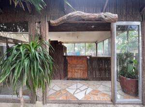 an open door of a house with a plant at Akkaw Baler Hometel in Baler