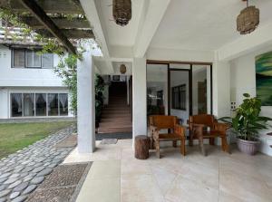 a porch of a house with chairs and a table at Akkaw Baler Hometel in Baler