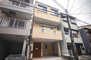 un edificio de apartamentos con un poste de servicio delante de él en 五卧室别墅 毗邻大阪城公园 en Osaka