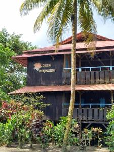 un edificio con una palmera delante de él en Casa Majagua La Barra, en Buenaventura