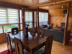 a wooden dining room with a table and a couch at Cabañas kavizke in Puerto Puyuhuapi