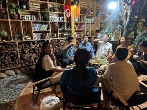 a group of people sitting around a table in a room at Gió Homestay in Xuan An