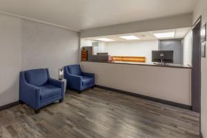 a waiting room with two blue chairs and a counter at Super 8 by Wyndham Laredo in Laredo