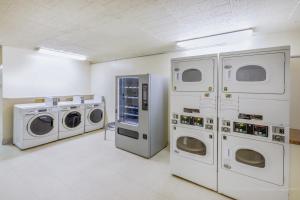 a laundry room with three washing machines and a dryer at Super 8 by Wyndham Laredo in Laredo