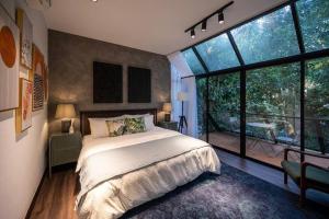 a bedroom with a large bed and a large window at The Estate Hulu Rening - Private Retreat Cabin in Batang Kali