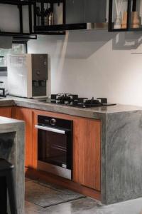 uma cozinha com um balcão com um fogão e um micro-ondas em The Estate Hulu Rening - Private Retreat Cabin em Batang Kali