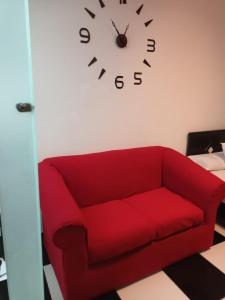 - un canapé rouge dans une chambre avec une horloge murale dans l'établissement Apartment in Zamalek, au Caire