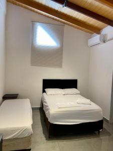 2 camas individuales en una habitación con ventana en Unidades mobiliadas em condomínio, en Lucas do Rio Verde