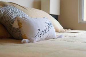 een kussen met het woord kounded zit op een bed bij Cozy & Quiet Pet friendly Studio in Ensenada