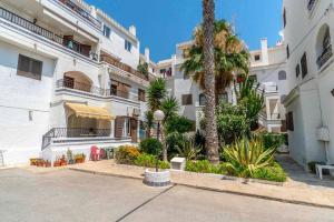 a building with a palm tree in front of it at Playa Flamenca Splendid apartment on the beach in Alicante