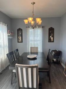 a dining room with a black table and chairs at The Cozy Place In Rochester, NY in West Henrietta +3 photos