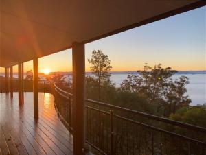 a balcony with a view of the ocean at sunset at The View @ Ulandi in Lowther