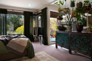 1 dormitorio con 1 cama y algunas macetas en Treehouse Spa Villa Daylesford, en Daylesford