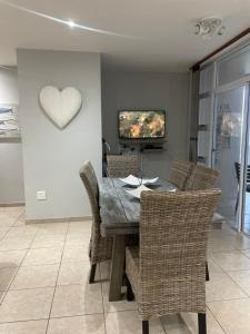 a dining room table with chairs and a heart on the wall at Dawn's Apartment in Margate