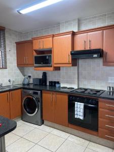 cocina con fogones y lavavajillas en Dawn's Apartment en Margate