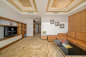 a living room with a couch and a television at Diamond Sea Hotel in Danang