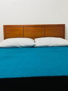 a bed with a wooden headboard and two pillows at Bogotá Kings 101 in Bogotá