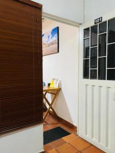 - une porte menant à une chambre avec une table et un bureau dans l'établissement Bogotá Kings 101, à Bogotá