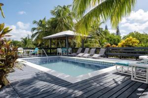 a pool with chairs and a table on a wooden deck at Trident Estate estate in Palmetto Point