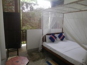 1 dormitorio con 1 cama con dosel en Jasmine Resort Thalalla en Talalla South