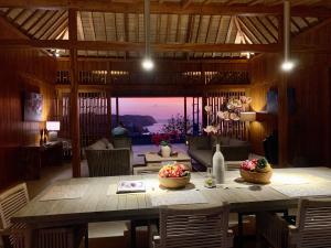 a dining room with a table and a view of the ocean at Lobster Bay Lombok in Awang
