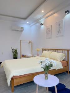 1 dormitorio con 1 cama grande y 1 mesa en Le Petit Homestay en Hue