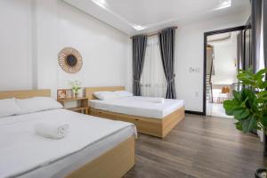 1 dormitorio con 2 camas y ventana en Le Petit Homestay en Hue