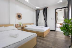 a bedroom with two beds and a window at Le Petit Homestay in Hue +17 photos