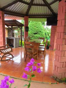 een patio met een tafel en stoelen en paarse bloemen bij Los Cipreses-10persons-Deep connection with nature 