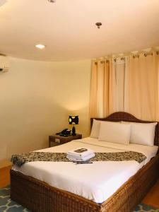Un dormitorio con una cama con un libro. en Grande Vista Hotel en Puerto Princesa