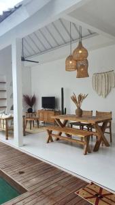 ein Wohnzimmer mit einem Holztisch und Bänken in der Unterkunft 2 bed luxury w pool by Melasti Beach in Uluwatu