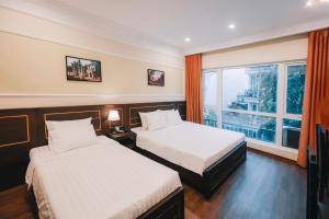 a hotel room with two beds and a window at Lake View Hotel & Travel in Hanoi
