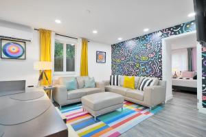 a living room with two couches and a colorful wall at Vacay Spot Wynwood Retreat 6 to 42 Guests 6 Kitchens Shower Massage jets, BBQ, Patio LED vibes, Prime LOC! 6 blocks away 4rm Bars, Nite Clubs, Res, Shops in Miami