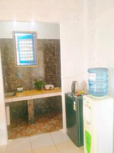 a small kitchen with a counter and a small refrigerator at Rumah Pantai Krui in Wainapal