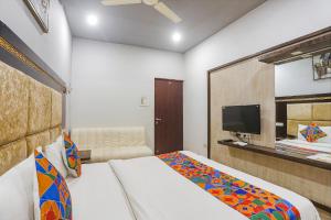 a hotel room with a bed and a tv at FabHotel Star Residency in Nagpur