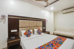 a bedroom with a large bed and a couch at FabHotel Star Residency in Nagpur