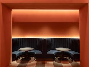 a room with two tables and a bench at Hotel Il Palazzo in Fukuoka
