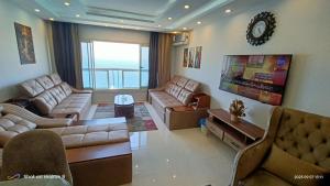 a large living room with couches and a tv at Gleem Luxury Condo Direct Sea view G18 in Alexandria