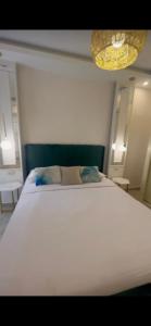 a large white bed in a room with a light at Madinaty, Elite new studio families and married couples only in Madinaty
