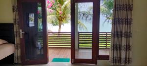 an open door to a patio with a palm tree at Panorama Seulako in Sabong