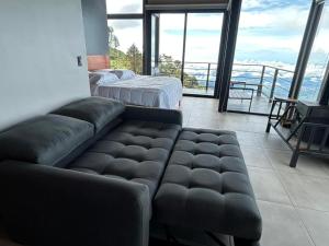 ein Wohnzimmer mit einem Sofa und einem Balkon in der Unterkunft Villas Páramo Cloud Forest Hotel in División